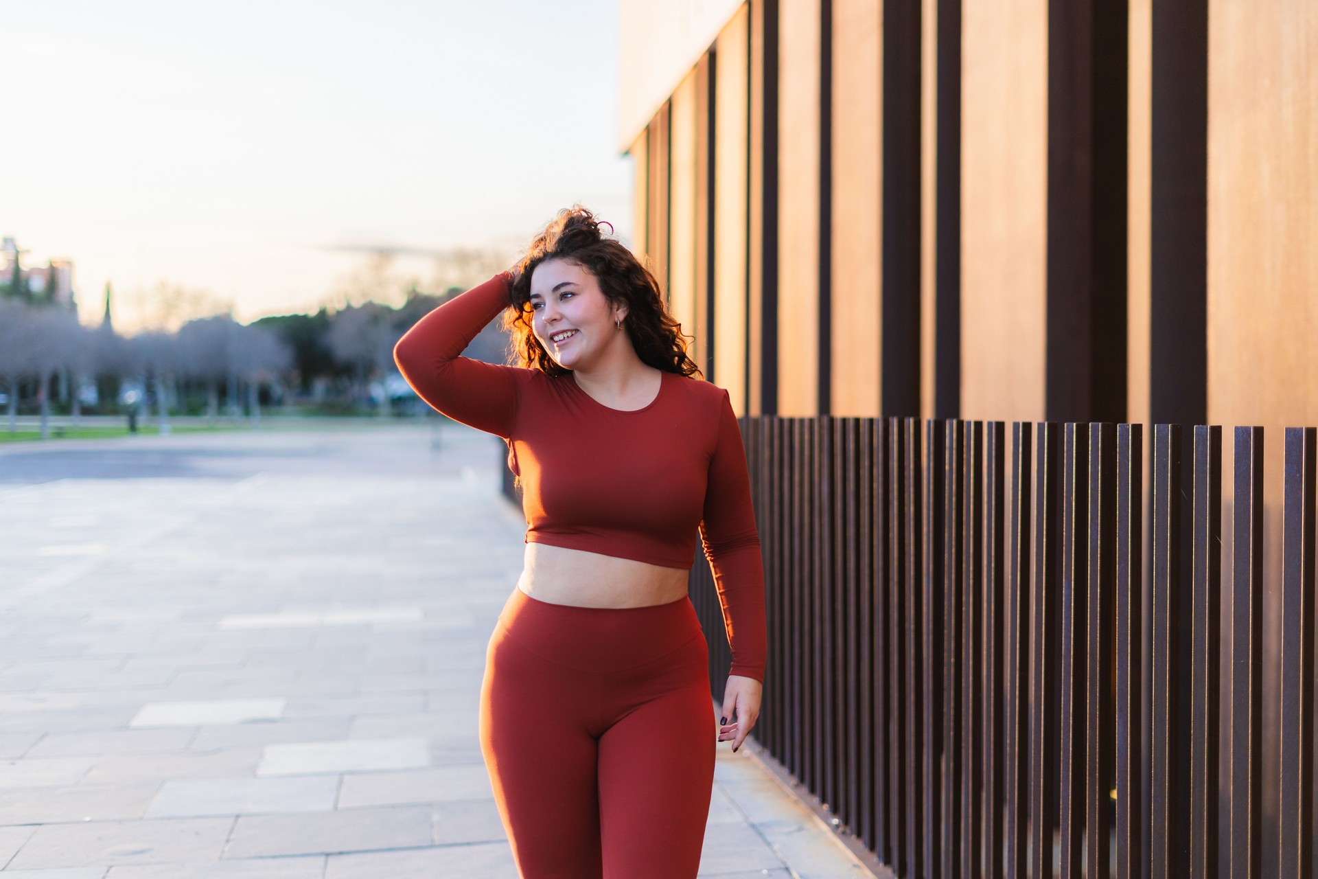 Curvy young woman wearing red sportswear walking in the city
