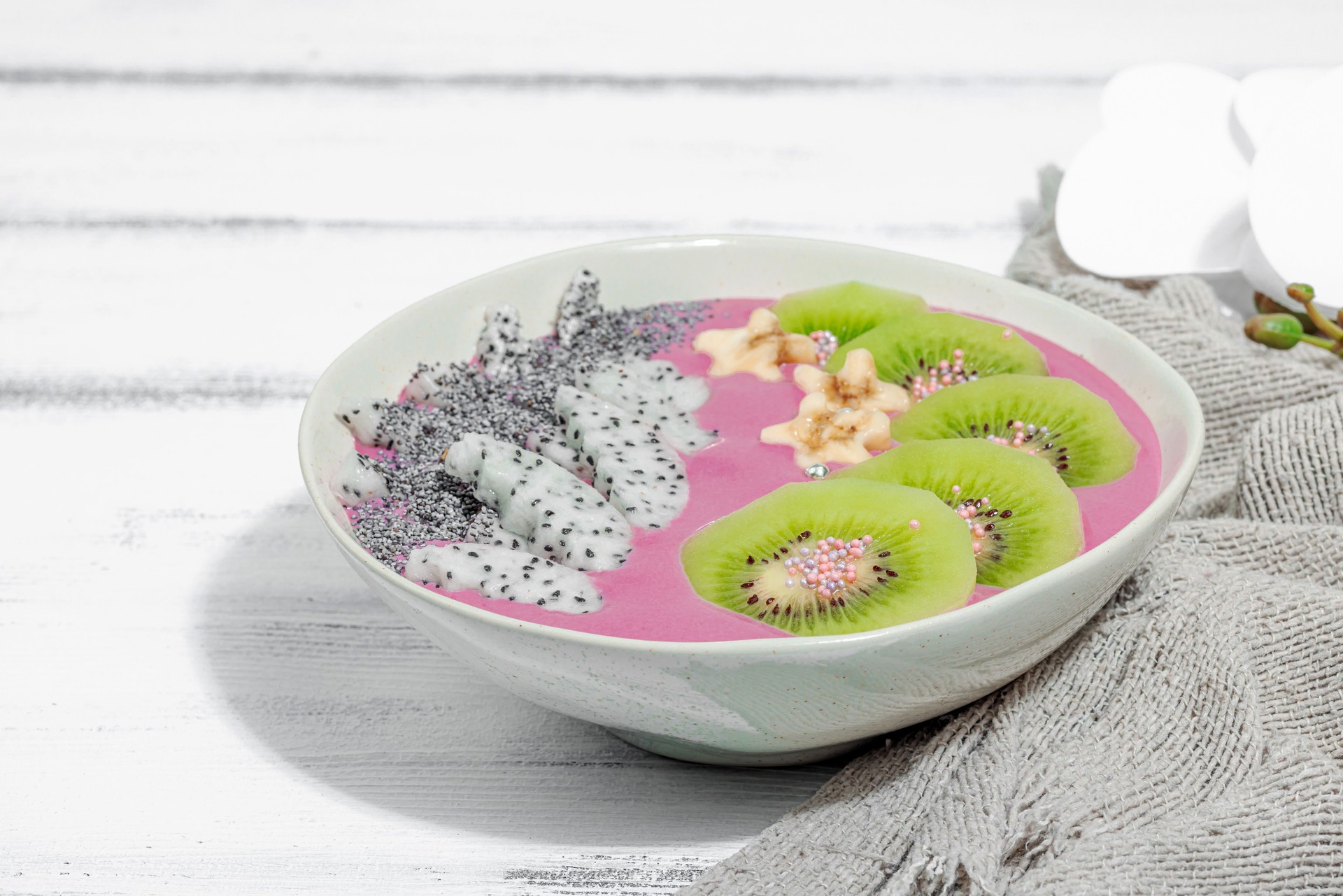 Pitaya smoothie bowl with fruit, kiwi, banana, and poppy seeds. Trendy food, healthy breakfast idea